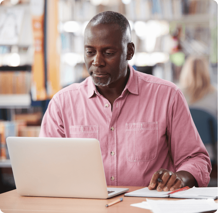 Man sitting at desk with laptop open 